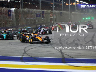 Lando Norris of the United Kingdom and McLaren Formula 1 Team drives on the opening lap during the F1 Grand Prix of Singapore at Marina Bay...