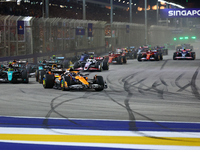 Lando Norris of the United Kingdom and McLaren Formula 1 Team drives on the opening lap during the F1 Grand Prix of Singapore at Marina Bay...