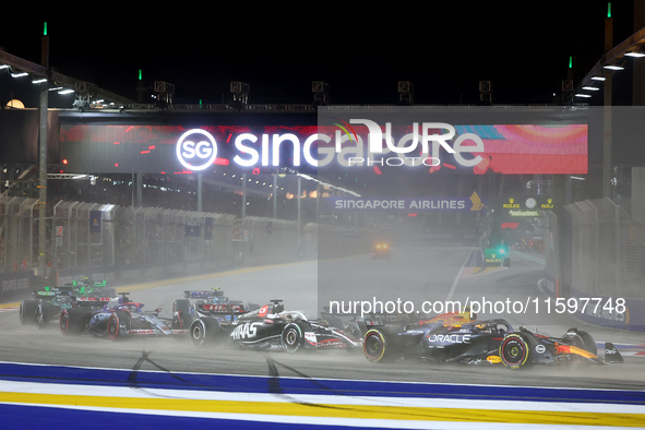 Sergio Perez of Mexico drives the Red Bull Racing-Honda RBPT RB20 on the opening lap during the F1 Grand Prix of Singapore at Marina Bay Str...