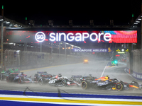 Sergio Perez of Mexico drives the Red Bull Racing-Honda RBPT RB20 on the opening lap during the F1 Grand Prix of Singapore at Marina Bay Str...