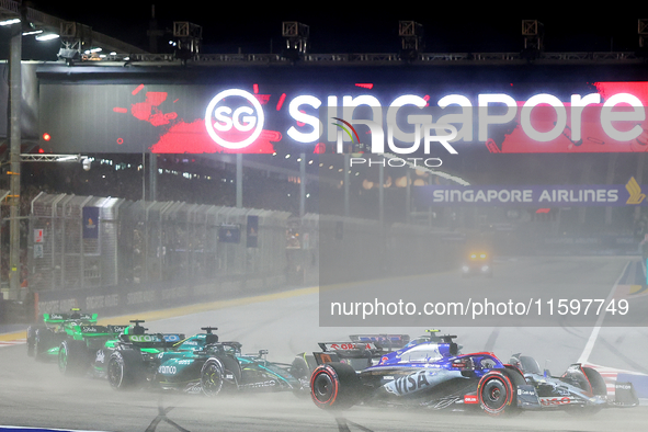 Daniel Ricciardo of Australia drives the Visa Cash App RB F1 Team VCARB 01 on the opening lap during the F1 Grand Prix of Singapore at Marin...