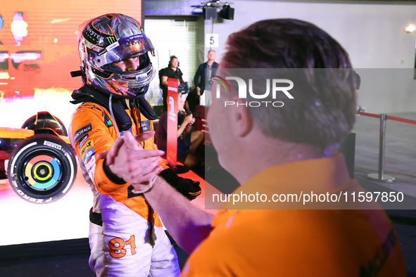 Oscar Piastri of Australia and the McLaren Formula 1 Team reacts with Zak Brown following the F1 Grand Prix of Singapore at Marina Bay Stree...