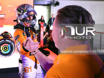 Oscar Piastri of Australia and the McLaren Formula 1 Team reacts with Zak Brown following the F1 Grand Prix of Singapore at Marina Bay Stree...