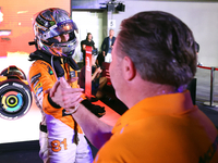 Oscar Piastri of Australia and the McLaren Formula 1 Team reacts with Zak Brown following the F1 Grand Prix of Singapore at Marina Bay Stree...