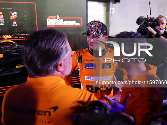 Zak Brown, CEO of McLaren Racing, and Andrea Stella, Team Principal of McLaren F1 Team, chat with Lando Norris of the United Kingdom and McL...