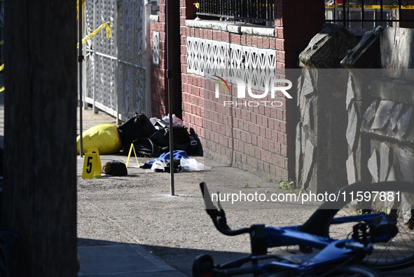 NYPD crime scene investigators search and mark evidence after a 42-year-old man is killed by gunshots to the shoulder and arm in the East Ne...