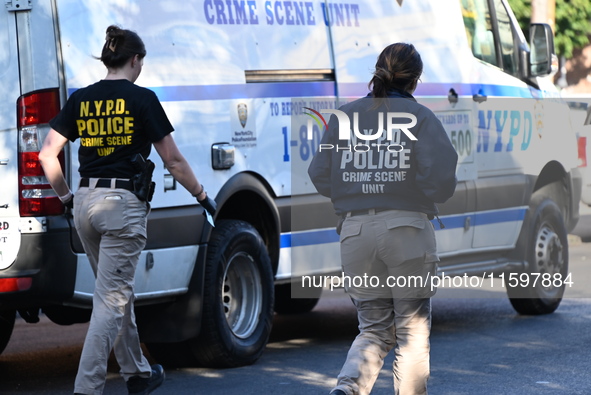 NYPD crime scene investigators search and mark evidence after a 42-year-old man is killed by gunshots to the shoulder and arm in the East Ne...