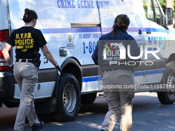 NYPD crime scene investigators search and mark evidence after a 42-year-old man is killed by gunshots to the shoulder and arm in the East Ne...