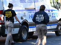 NYPD crime scene investigators search and mark evidence after a 42-year-old man is killed by gunshots to the shoulder and arm in the East Ne...