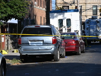 NYPD crime scene investigators search and mark evidence after a 42-year-old man is killed by gunshots to the shoulder and arm in the East Ne...