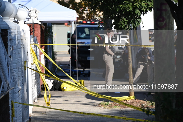 NYPD crime scene investigators search and mark evidence after a 42-year-old man is killed by gunshots to the shoulder and arm in the East Ne...