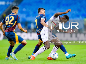 Christian Kabasele of Udinese Calcio and Lorenzo Pellegrini of AS Roma compete for the ball during the Serie A Enilive match between AS Roma...