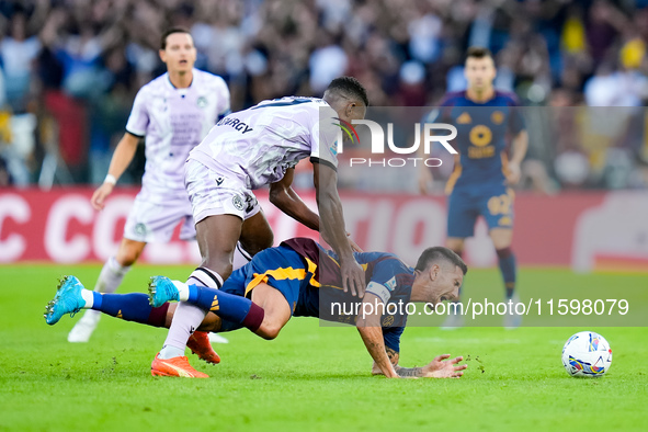 Christian Kabasele of Udinese Calcio and Lorenzo Pellegrini of AS Roma compete for the ball during the Serie A Enilive match between AS Roma...