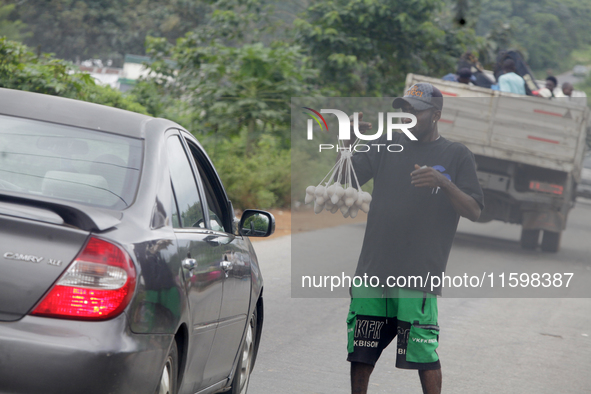 A man sells eggs along Ife-Ibadan Expressway in Osun State, Nigeria, on September 20, 2024. Many city dwellers and travelers opt to buy raw...