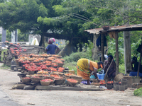 A woman arranges peppers along Ife-Ibadan Expressway in Osun State, Nigeria, on September 20, 2024. Many city dwellers and travelers opt to...