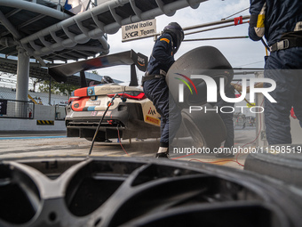 Marco Cassara, Philippe Denes, and Felice Jelmini of the BMW Italia Ceccato Racing team perform a pit stop on a BMW M4 GT3 during the Fanate...