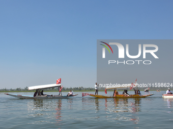 Supporters of the National Conference, a regional political party, hold a boat rally ahead of the second phase of assembly elections in Dal...