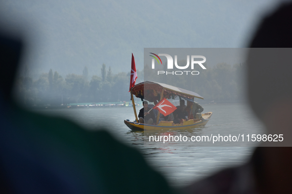 Supporters of the National Conference, a regional political party, hold a boat rally ahead of the second phase of assembly elections in Dal...