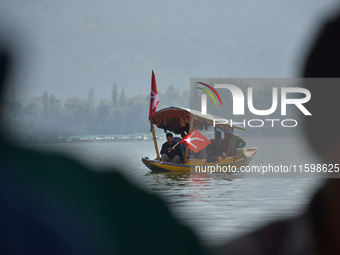 Supporters of the National Conference, a regional political party, hold a boat rally ahead of the second phase of assembly elections in Dal...