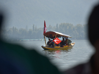 Supporters of the National Conference, a regional political party, hold a boat rally ahead of the second phase of assembly elections in Dal...