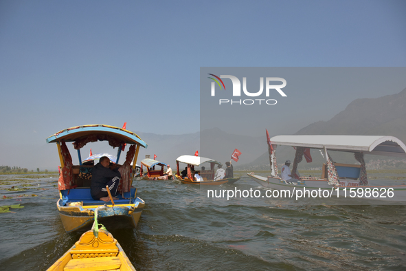 Supporters of the National Conference, a regional political party, hold a boat rally ahead of the second phase of assembly elections in Dal...