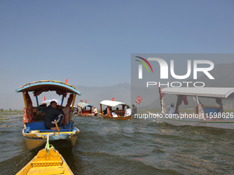 Supporters of the National Conference, a regional political party, hold a boat rally ahead of the second phase of assembly elections in Dal...