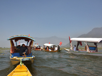 Supporters of the National Conference, a regional political party, hold a boat rally ahead of the second phase of assembly elections in Dal...