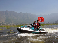 Supporters of the National Conference, a regional political party, hold a boat rally ahead of the second phase of assembly elections in Dal...