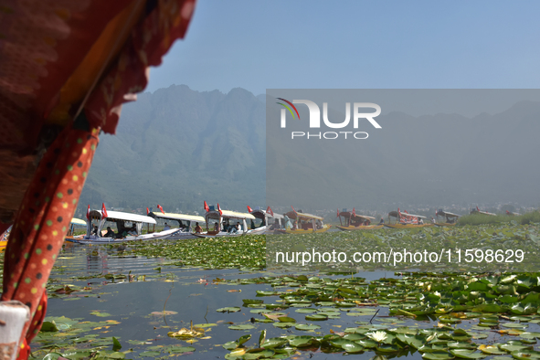 Supporters of the National Conference, a regional political party, hold a boat rally ahead of the second phase of assembly elections in Dal...