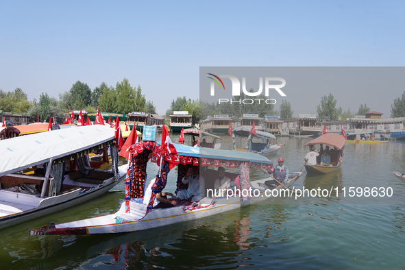 Supporters of the National Conference, a regional political party, hold a boat rally ahead of the second phase of assembly elections in Dal...