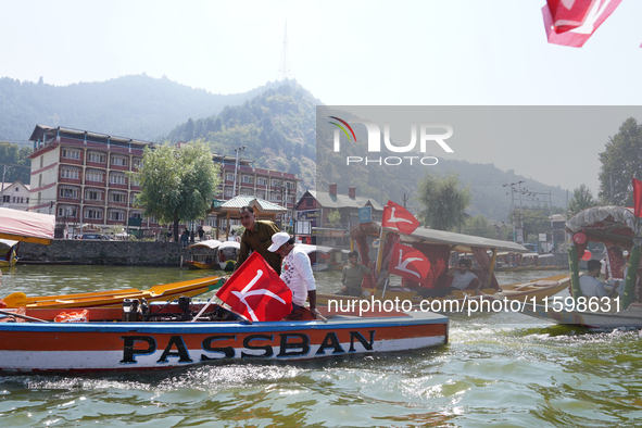 Supporters of the National Conference, a regional political party, hold a boat rally ahead of the second phase of assembly elections in Dal...