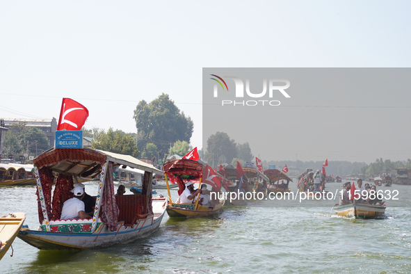 Supporters of the National Conference, a regional political party, hold a boat rally ahead of the second phase of assembly elections in Dal...