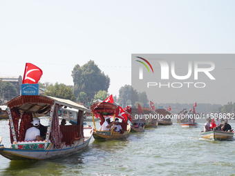 Supporters of the National Conference, a regional political party, hold a boat rally ahead of the second phase of assembly elections in Dal...