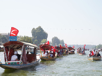 Supporters of the National Conference, a regional political party, hold a boat rally ahead of the second phase of assembly elections in Dal...