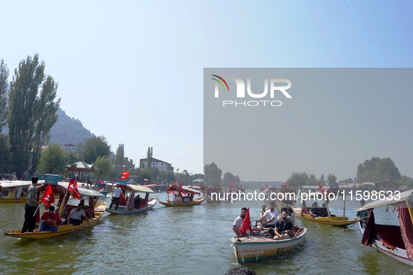 Supporters of the National Conference, a regional political party, hold a boat rally ahead of the second phase of assembly elections in Dal...