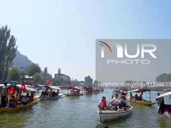 Supporters of the National Conference, a regional political party, hold a boat rally ahead of the second phase of assembly elections in Dal...