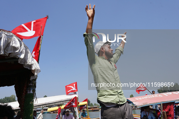 A supporter of the National Conference, a regional political party, shouts slogans during a boat rally ahead of the second phase of assembly...