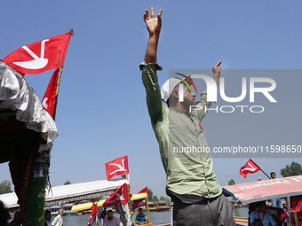 A supporter of the National Conference, a regional political party, shouts slogans during a boat rally ahead of the second phase of assembly...