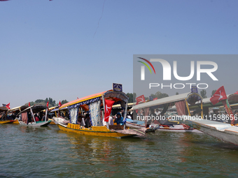 Supporters of the National Conference, a regional political party, hold a boat rally ahead of the second phase of assembly elections in Dal...