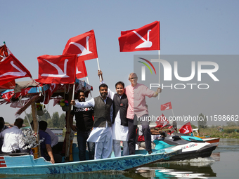 Omar Abdullah, leader of the National Conference, a regional political party, holds his party flag during a boat rally ahead of the second p...