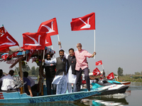 Omar Abdullah, leader of the National Conference, a regional political party, holds his party flag during a boat rally ahead of the second p...