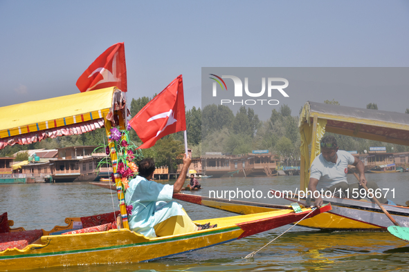 Supporters of the National Conference, a regional political party, hold a boat rally ahead of the second phase of assembly elections in Dal...