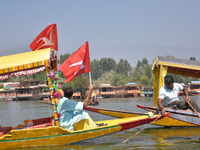 Supporters of the National Conference, a regional political party, hold a boat rally ahead of the second phase of assembly elections in Dal...