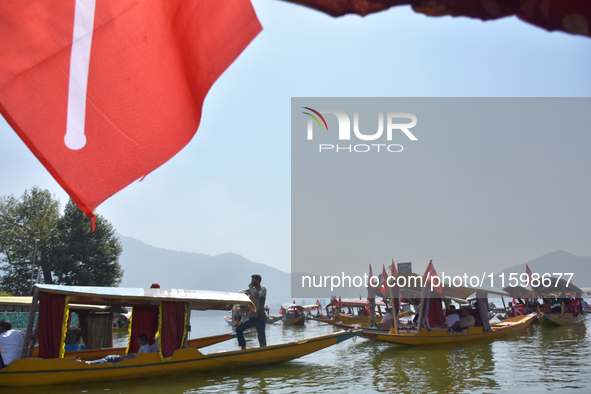 Supporters of the National Conference, a regional political party, hold a boat rally ahead of the second phase of assembly elections in Dal...