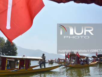 Supporters of the National Conference, a regional political party, hold a boat rally ahead of the second phase of assembly elections in Dal...