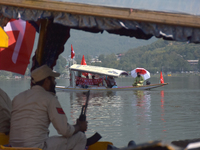 Supporters of the National Conference, a regional political party, hold a boat rally ahead of the second phase of assembly elections in Dal...