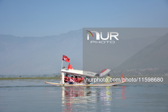 Supporters of the National Conference, a regional political party, hold a boat rally ahead of the second phase of assembly elections in Dal...