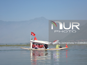 Supporters of the National Conference, a regional political party, hold a boat rally ahead of the second phase of assembly elections in Dal...