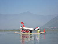 Supporters of the National Conference, a regional political party, hold a boat rally ahead of the second phase of assembly elections in Dal...