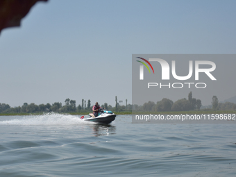 Omar Abdullah, leader of the National Conference, a regional political party, rides a jet ski during a boat rally ahead of the second phase...